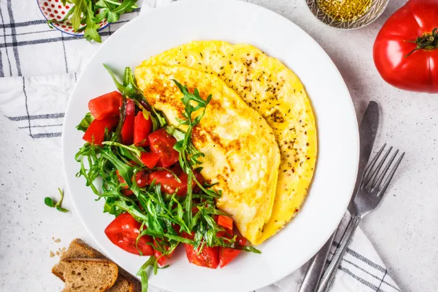 Photo of a high protein meal with 2 pieces of sunny side up and bacon.
